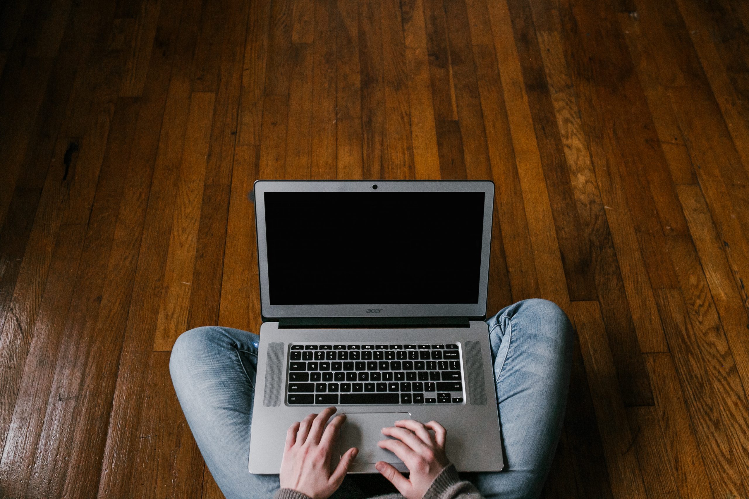 black screen laptop that is sitting on a lap of an accountant that is indian sitted