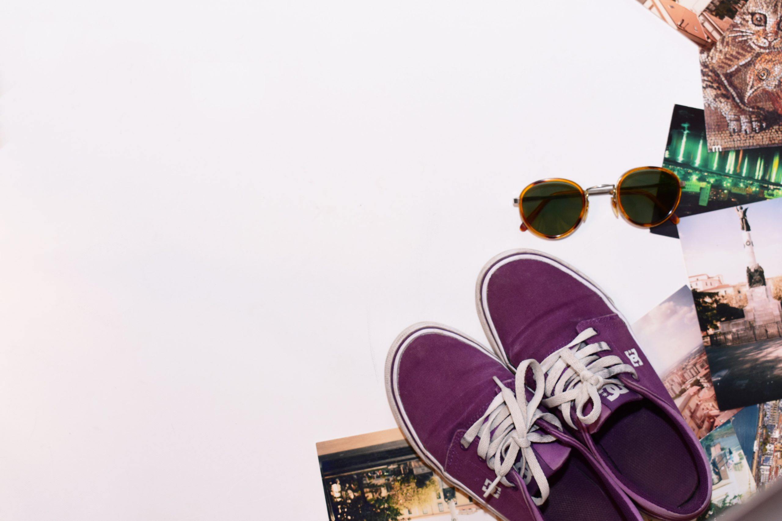 top view shot of shades blue shoes and photographs