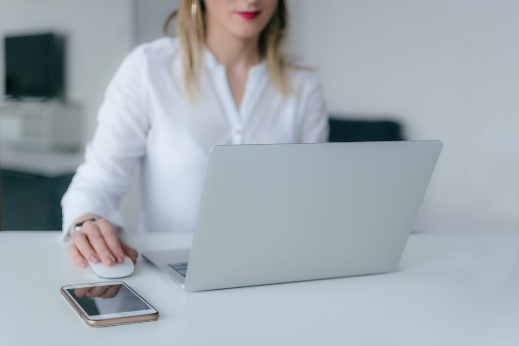 accountant working on her laptop beside her mobile phone