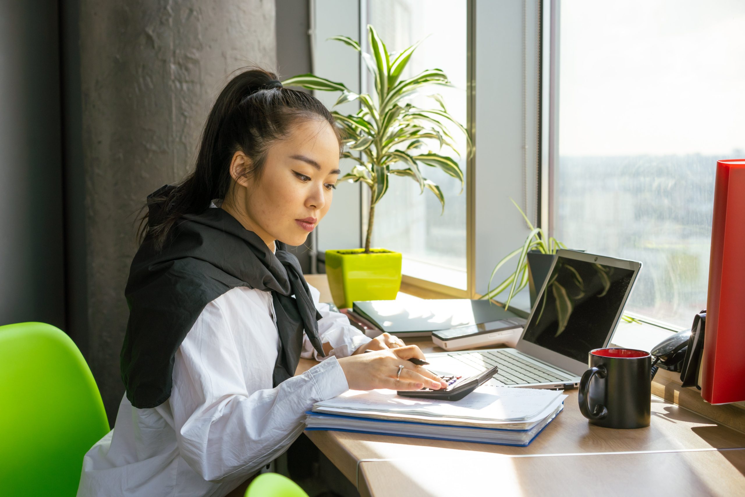 accountant computing the tax return of her client using a calculator