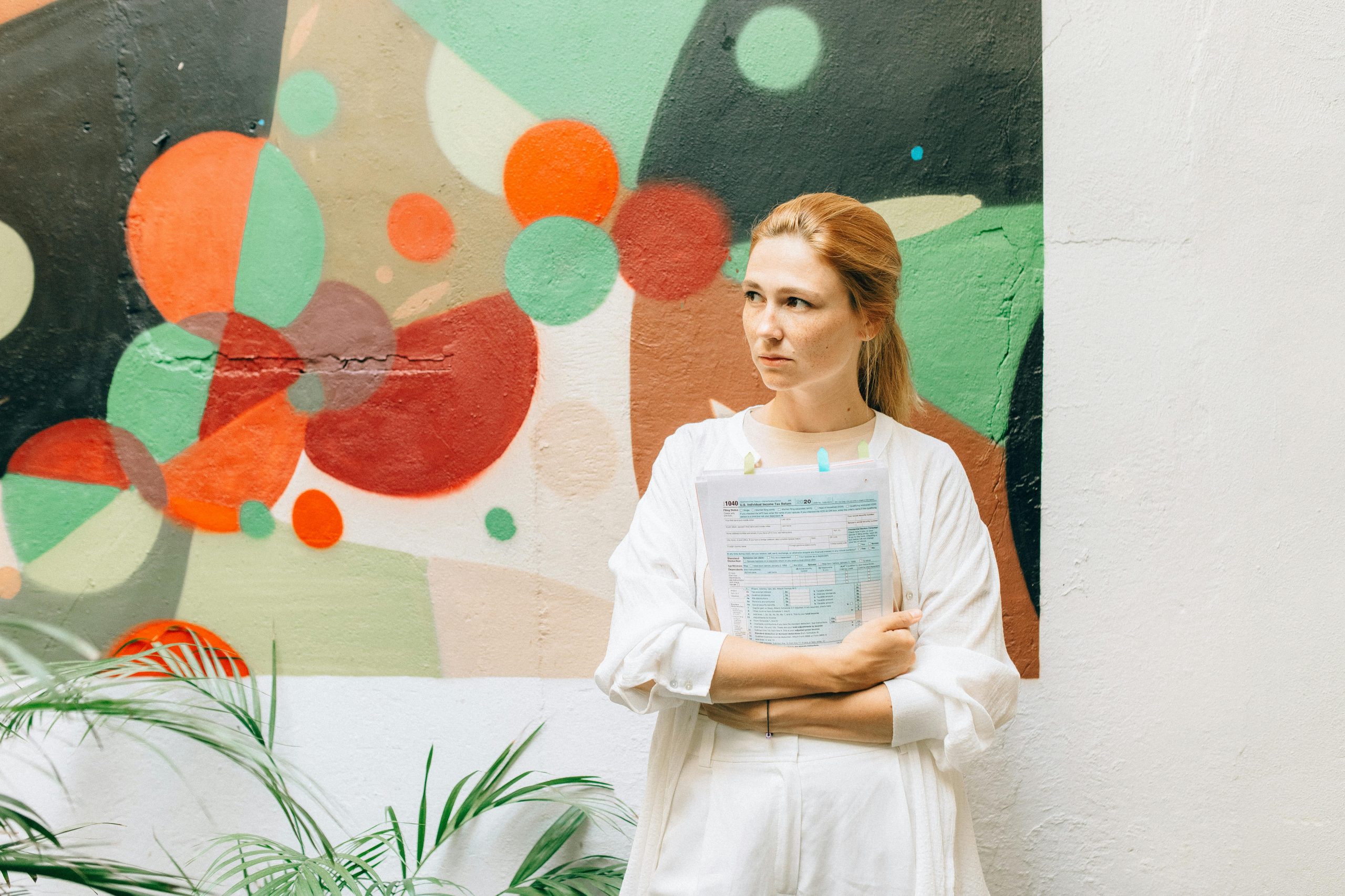 sad accountant standing beside a wall with mural art