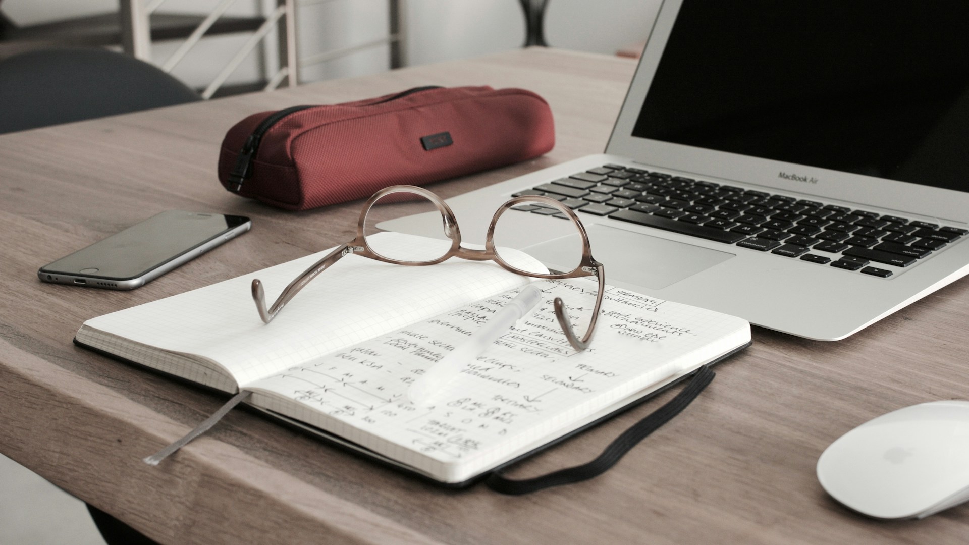 reading glasses on top of a notebook with accounting notes