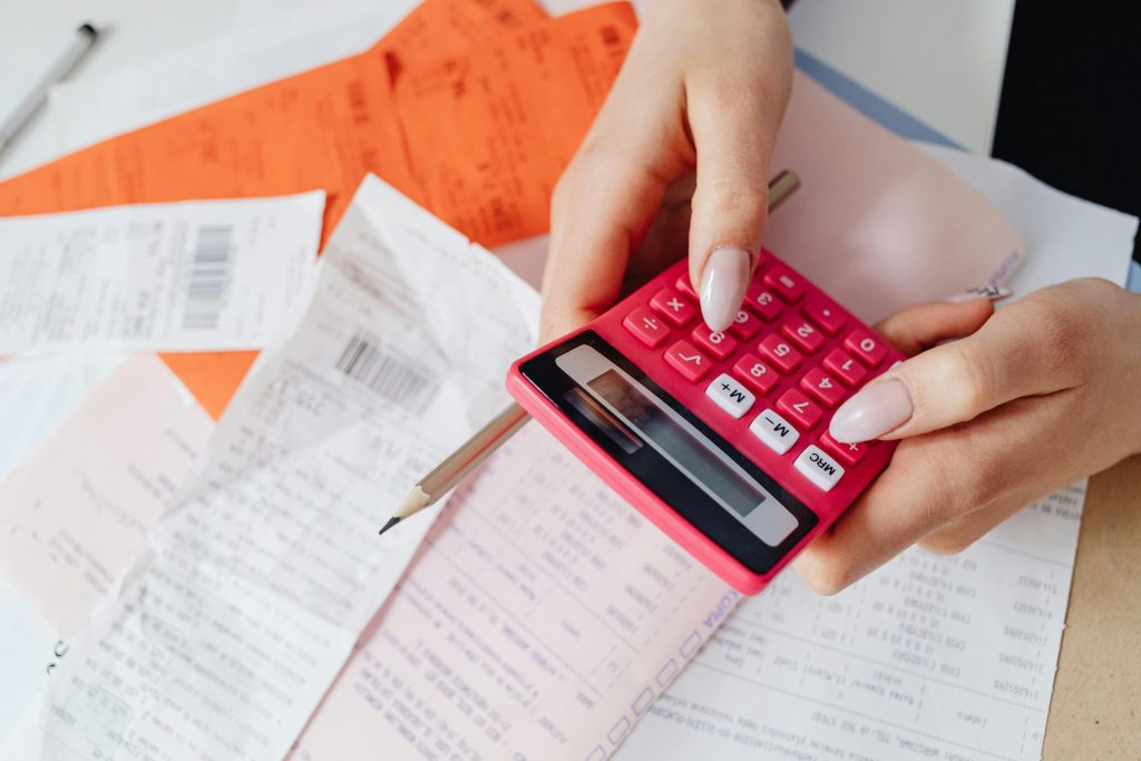 accountant using pink calculator to get tax return