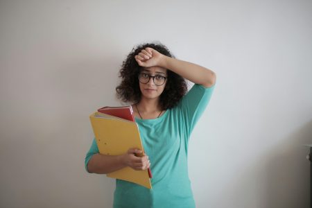 accountant having her hand on her forehead while holding files