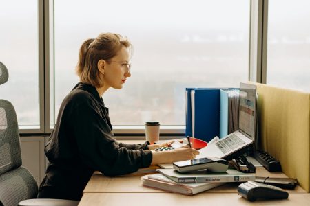 accountant with her coffee laptop and file of papers