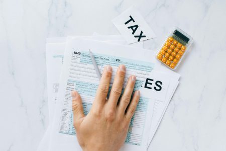 tax return papers with an orange calculator