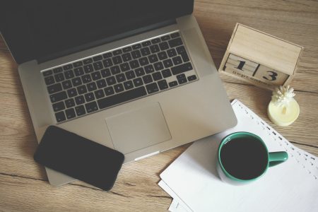 top view show of a laptop coffee mug and papers